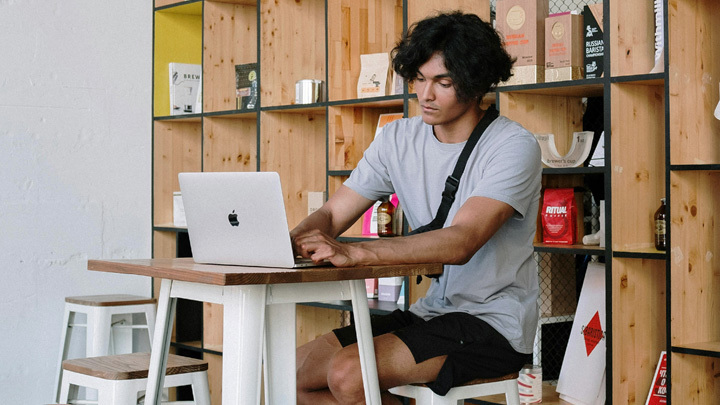 Man working on laptop at high table