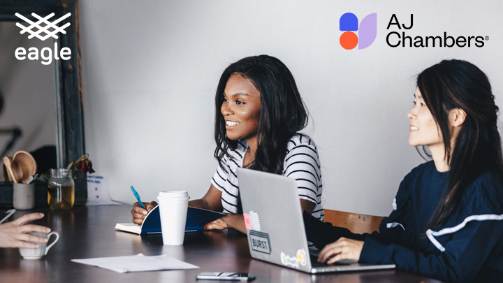 Two women working with AJ Chambers logo above them