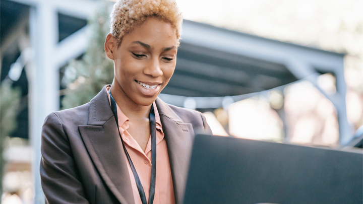 woman smiling whilst working at laptop