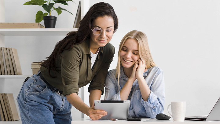 Two women at work looking at laptop